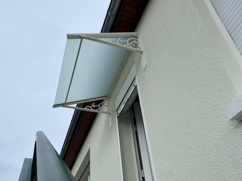 Entrée de maison protégée par une marquise aluminium blanche et vitrage opalin